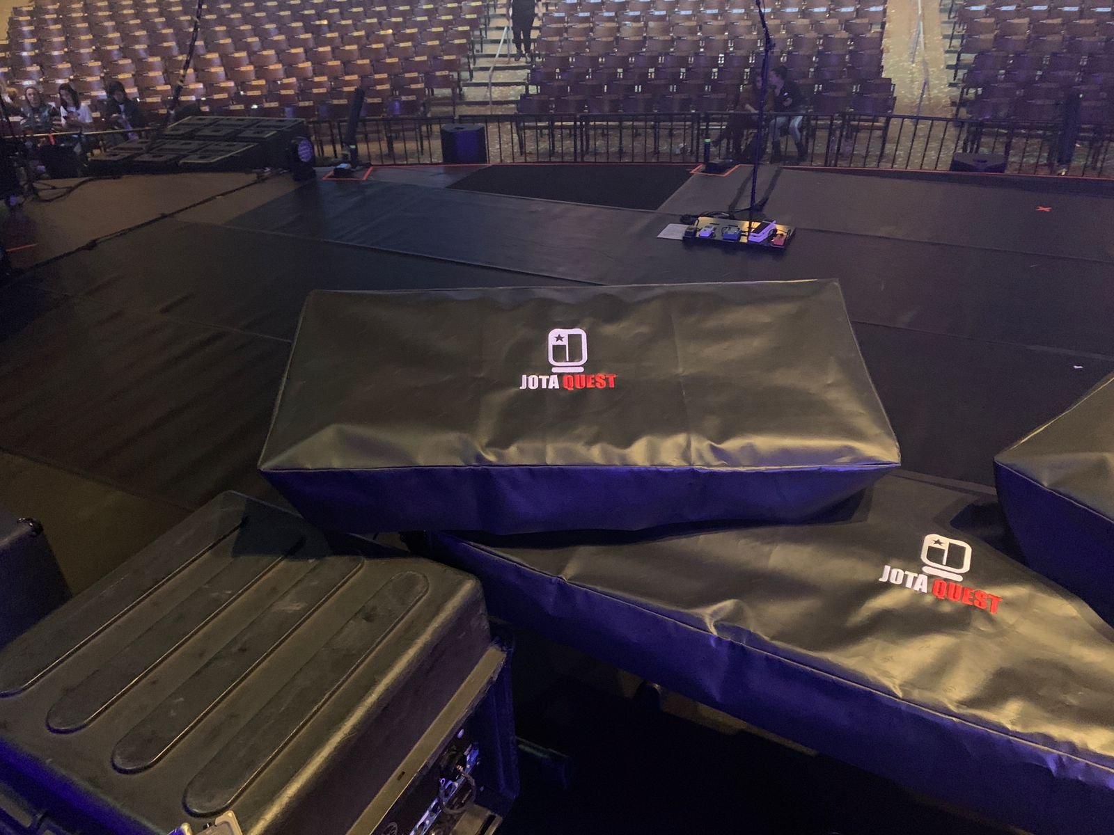 Capas pretas com a marca Jota Quest em equipamentos no palco